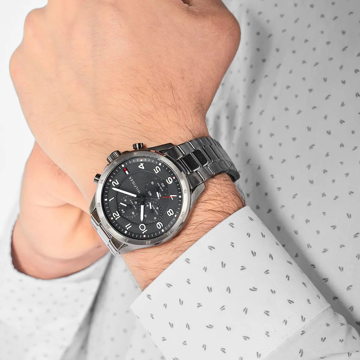 Tommy Hilfiger Axel grey chronograph watch worn on wrist with stainless steel bracelet
