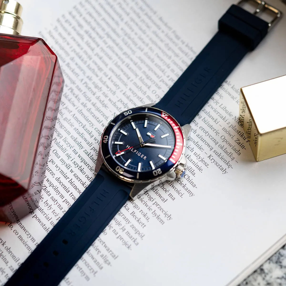 Tommy Hilfiger Logan watch on wrist displayed with lifestyle items