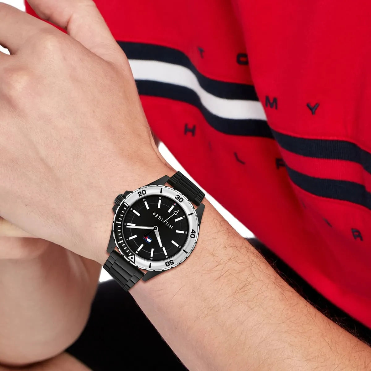 Tommy Hilfiger Logan men's watch on wrist with red clothing in background