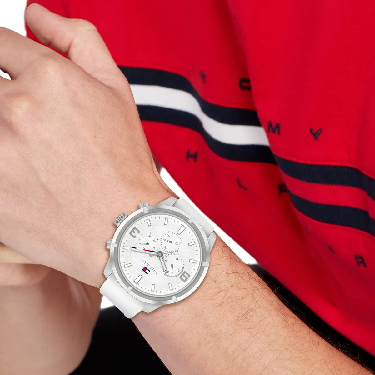 Tommy Hilfiger Wild white chronograph watch worn on wrist with red Tommy Hilfiger shirt