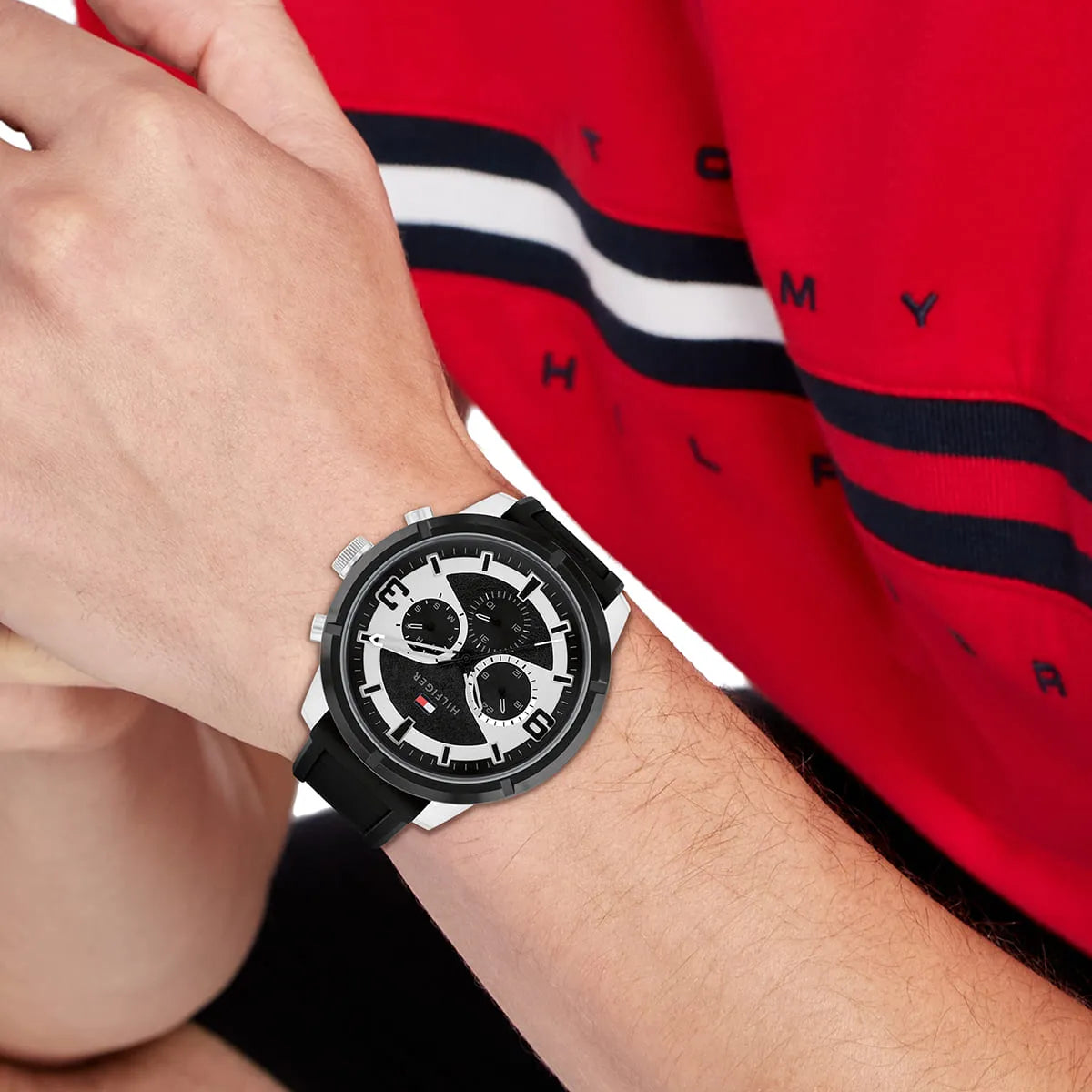 Tommy Hilfiger Wild watch worn on wrist with red Tommy Hilfiger shirt in background