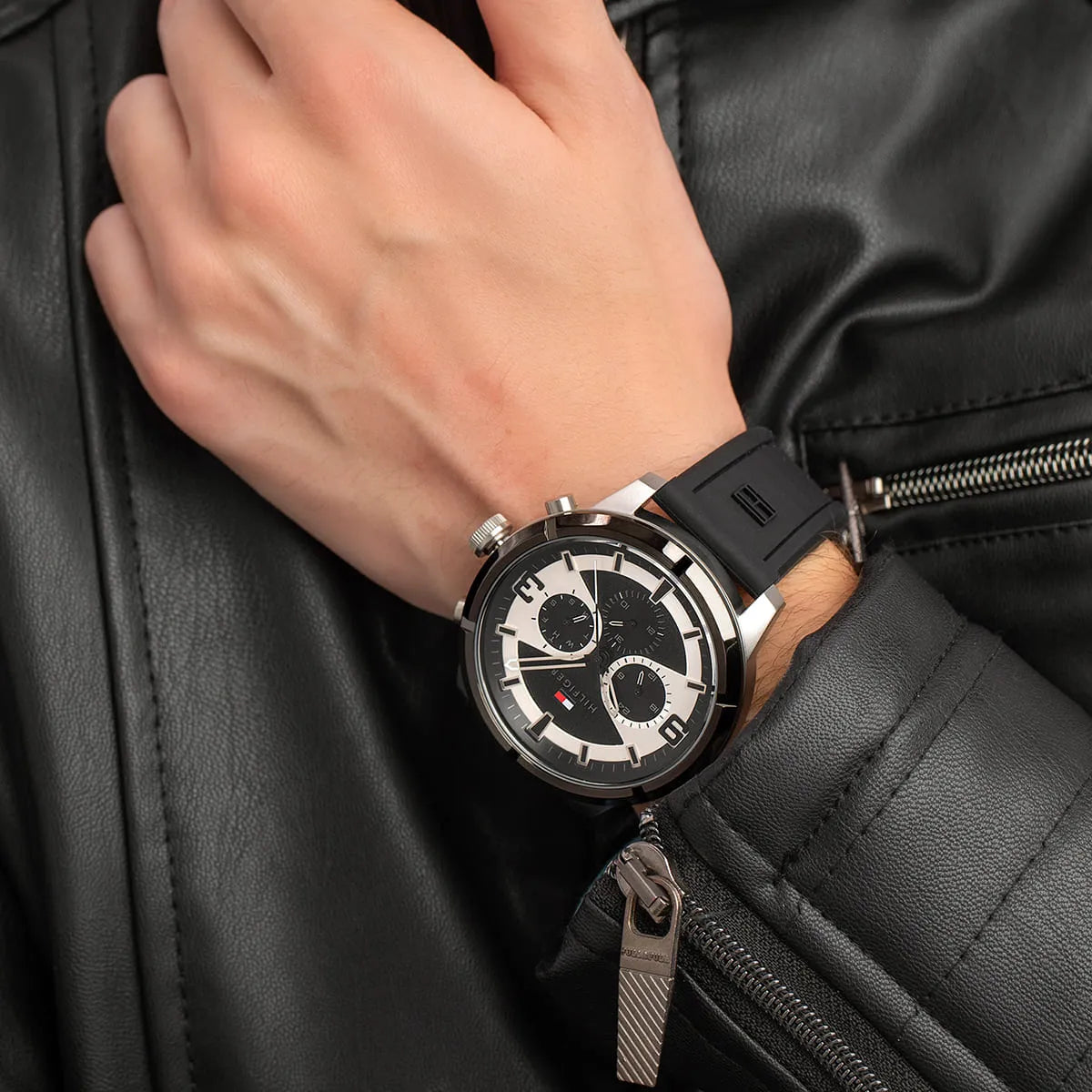 Tommy Hilfiger Wild watch on wrist showing dial and rubber strap against black jacket