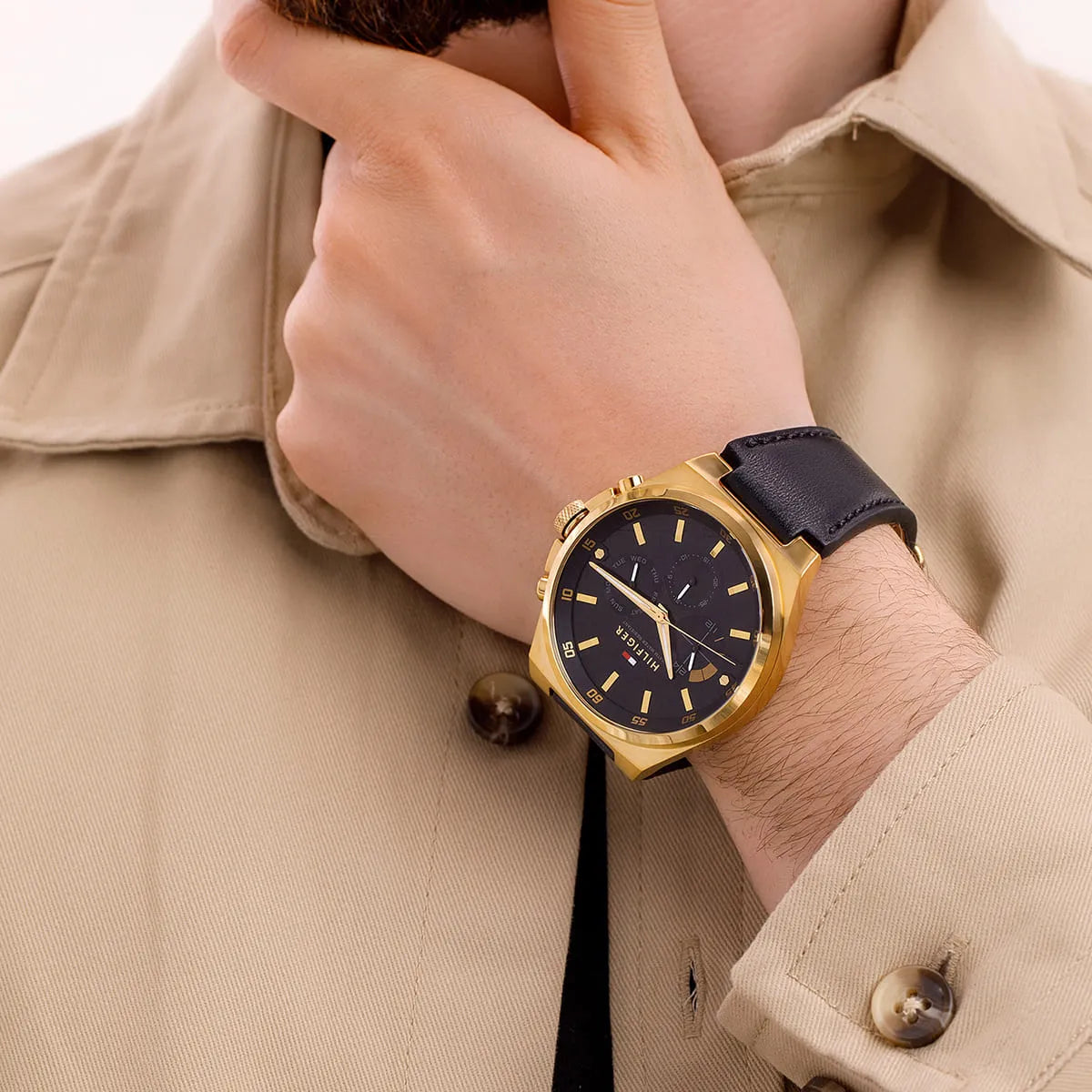 Tommy Hilfiger Dexter chronograph watch on wrist with gold case and navy leather strap