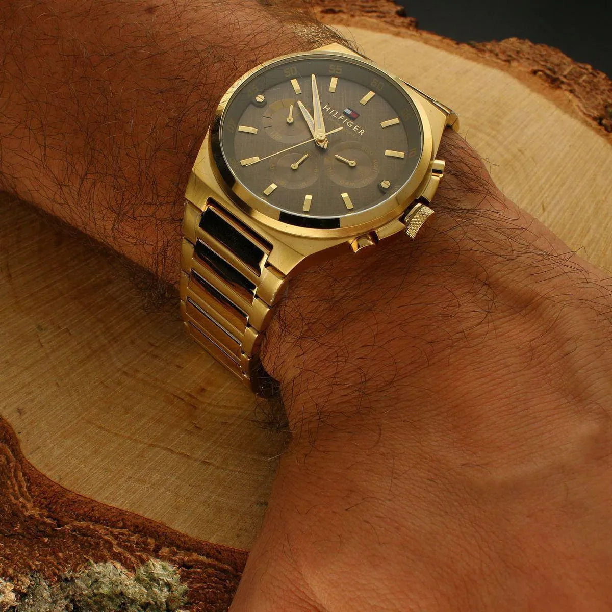 Tommy Hilfiger Dexter watch worn on wrist showing brown dial and gold strap