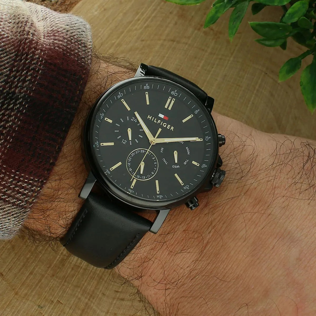 Tommy Hilfiger TYSON chronograph watch worn on wrist, showing black dial with gold hands and multifunction subdials