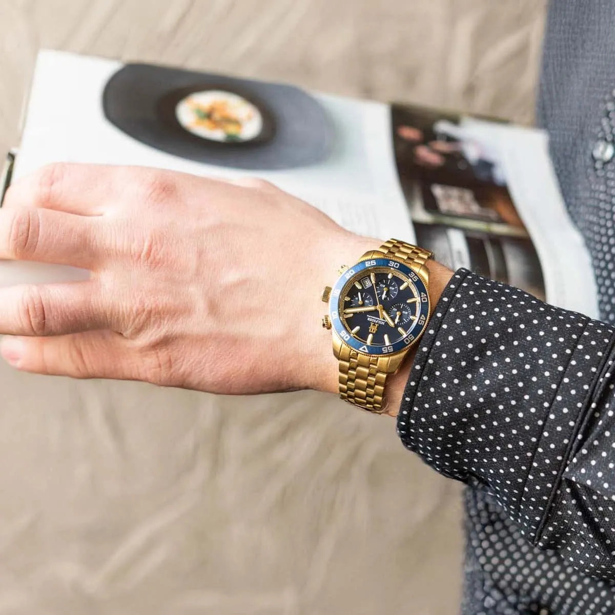 Tommy Hilfiger gold chronograph watch worn on wrist with blue dial and gold bracelet