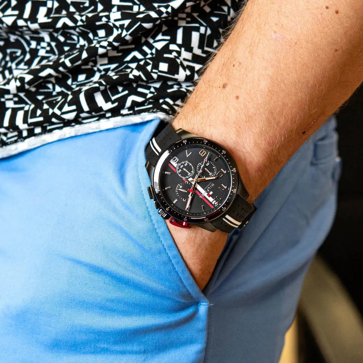 Tommy Hilfiger black chronograph watch worn on wrist with blue shirt sleeve