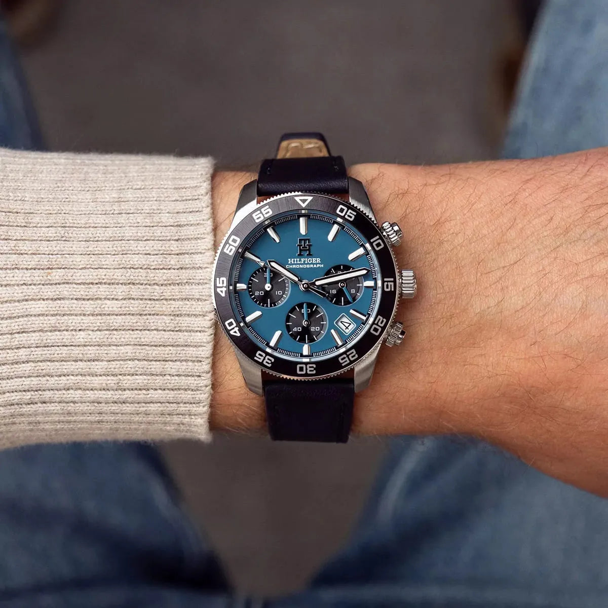 Tommy Hilfiger blue chronograph watch worn on wrist with beige sleeve