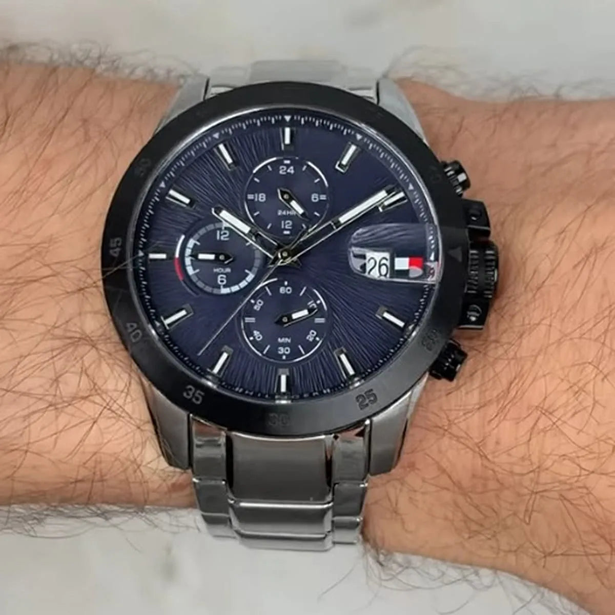 Tommy Hilfiger Jameson chronograph watch on male wrist showing blue dial and black bezel