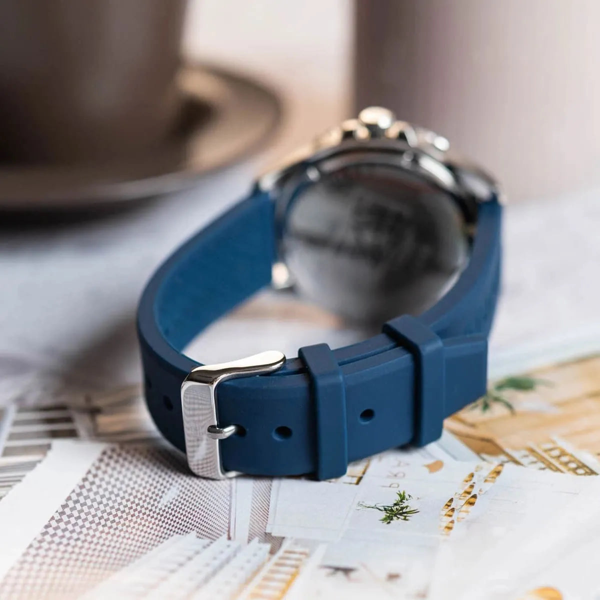 Tommy Hilfiger watch on wrist in lifestyle setting with fern plant and leather background
