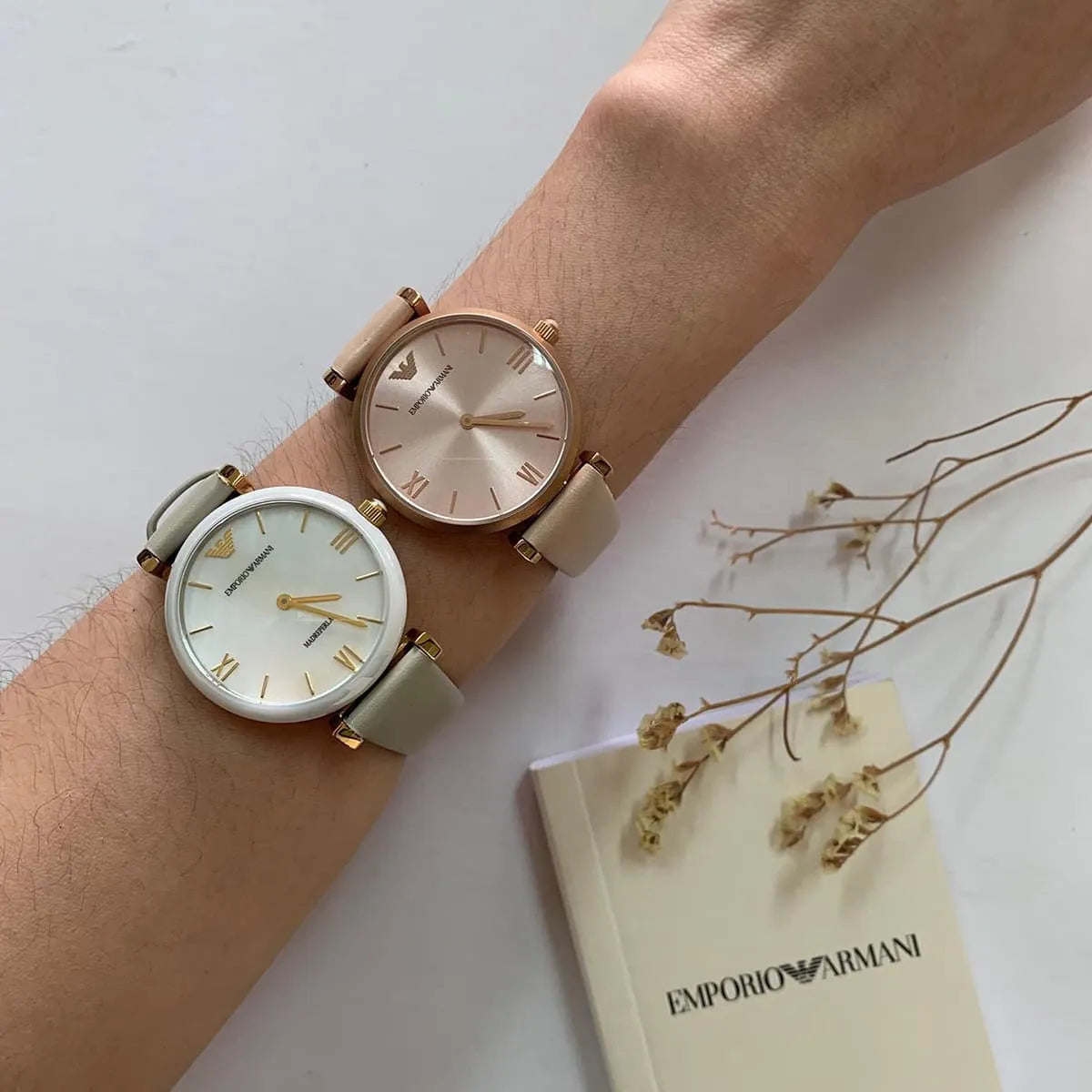 Two Emporio Armani Gianni T-Bar watches on wrist showing rose gold and alternative color options