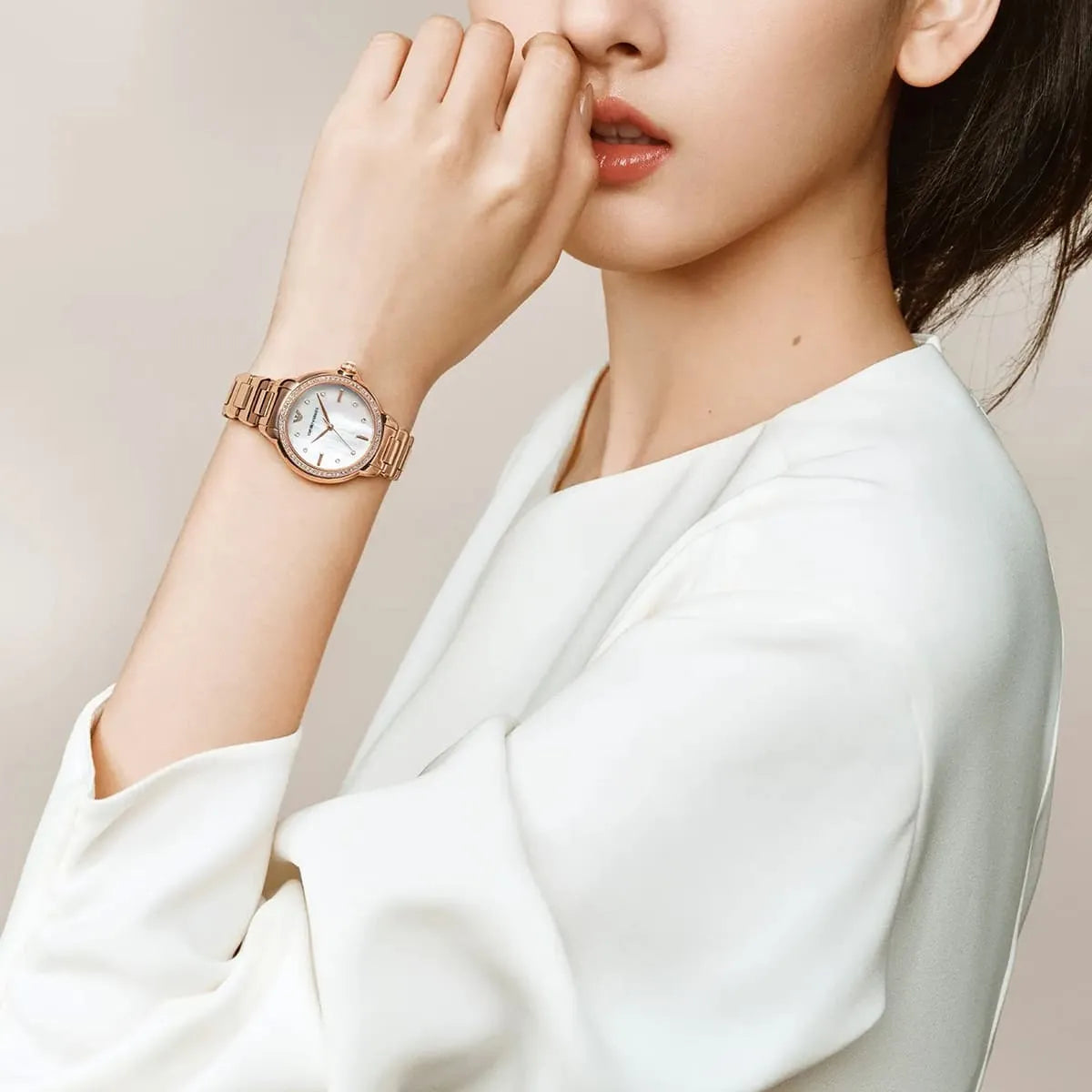 Emporio Armani Mia women's watch worn on wrist showing white mother-of-pearl dial and rose-gold case