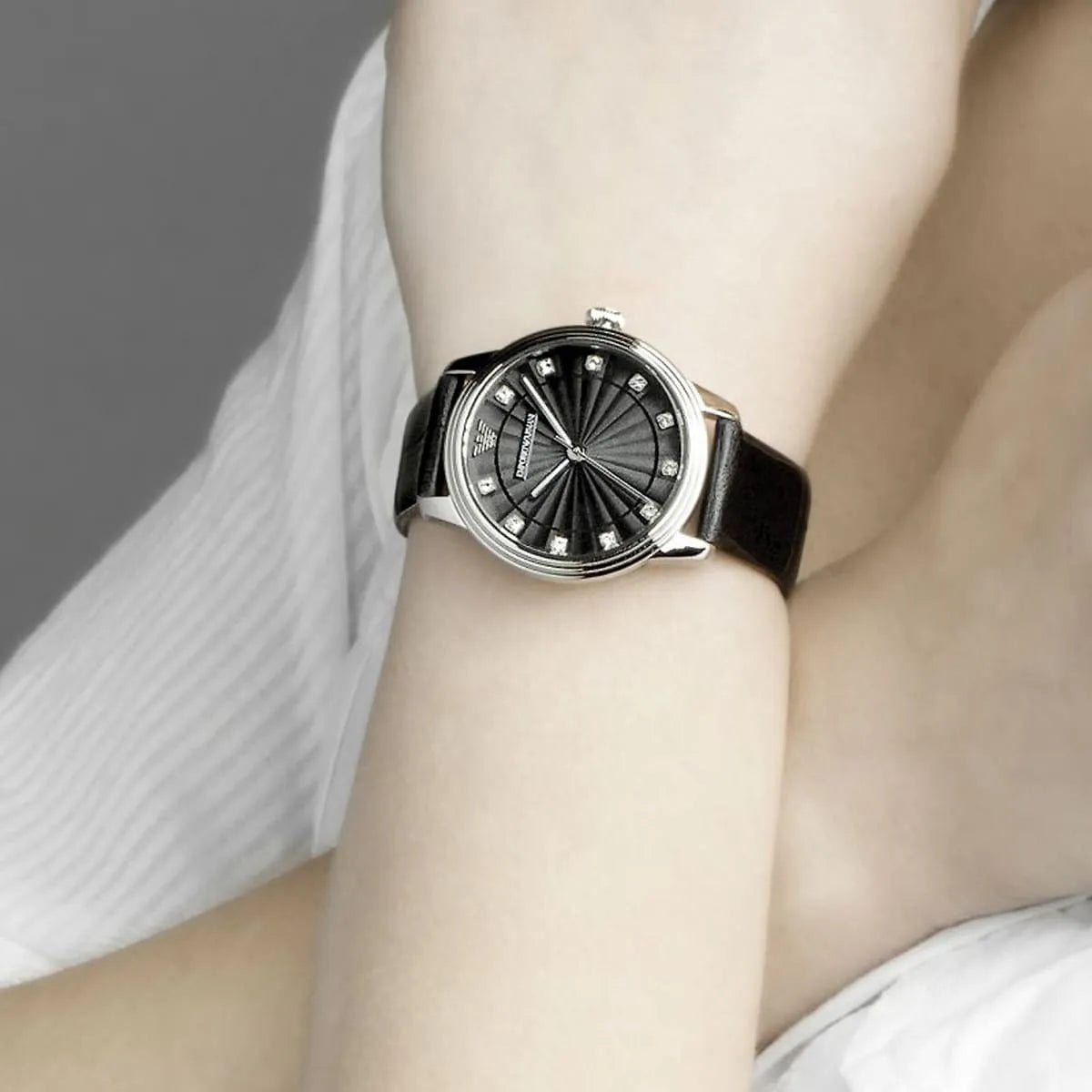 Emporio Armani Dino watch worn on wrist, displaying black dial with diamond indices and leather strap