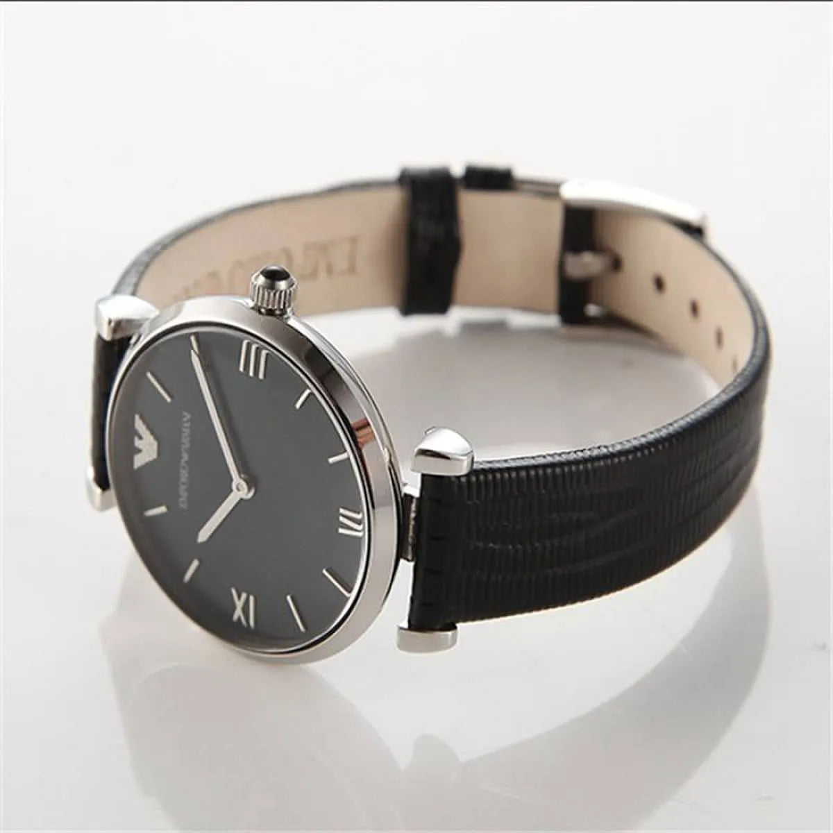 Emporio Armani Gianni T-Bar watch on wrist showing black dial, silver-tone case, and black leather strap