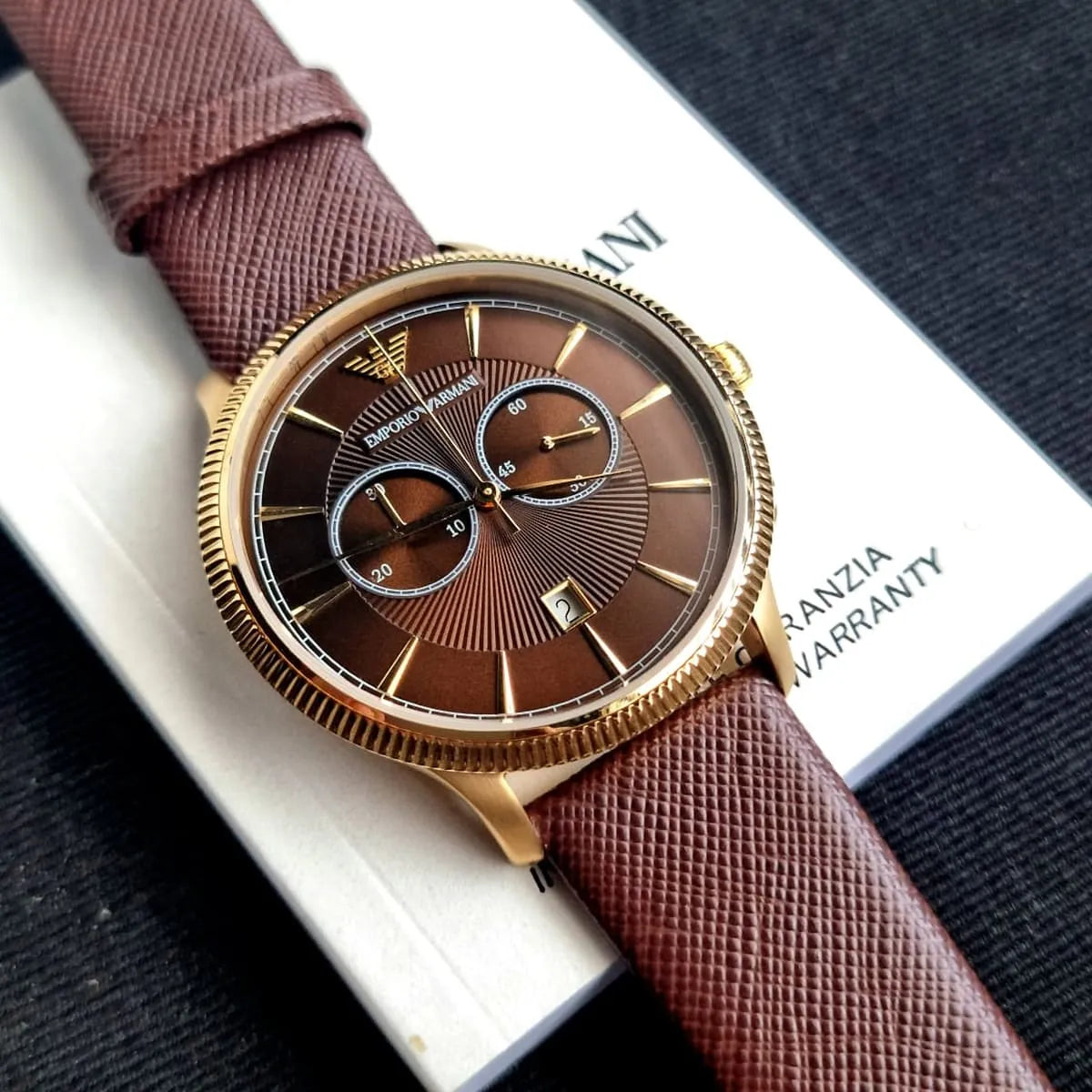 AR1793 on wrist with brown dial and brown leather strap on packaging