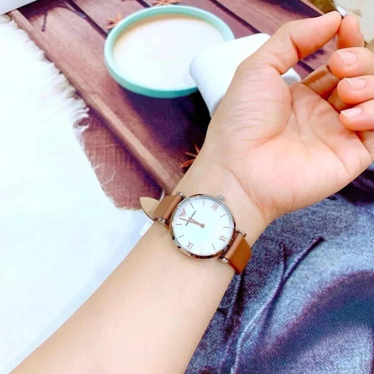 Emporio Armani AR1988 women's watch on wrist with brown leather strap in casual lifestyle setting