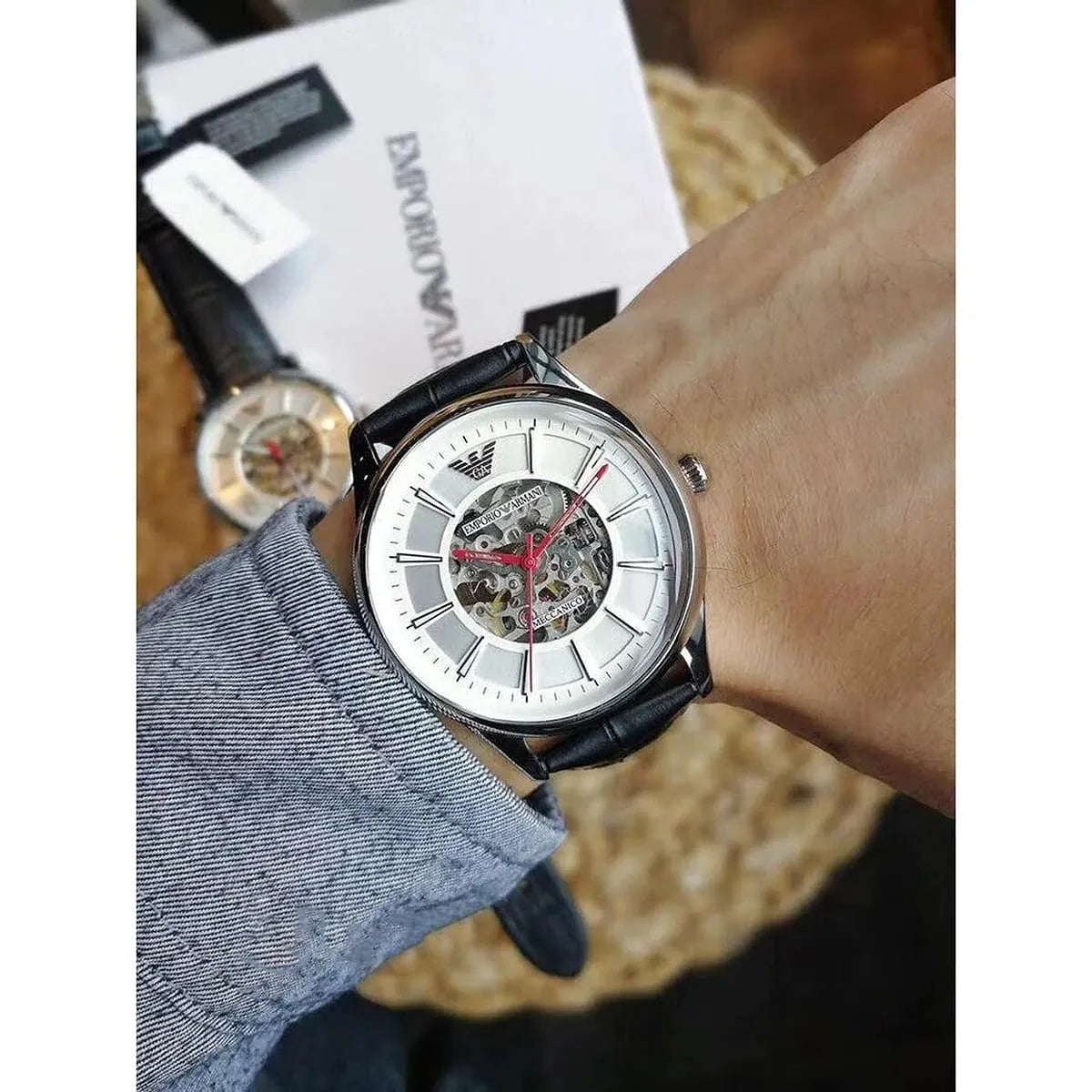 Emporio Armani AR2072 skeleton watch on wrist displaying silver dial with visible movement