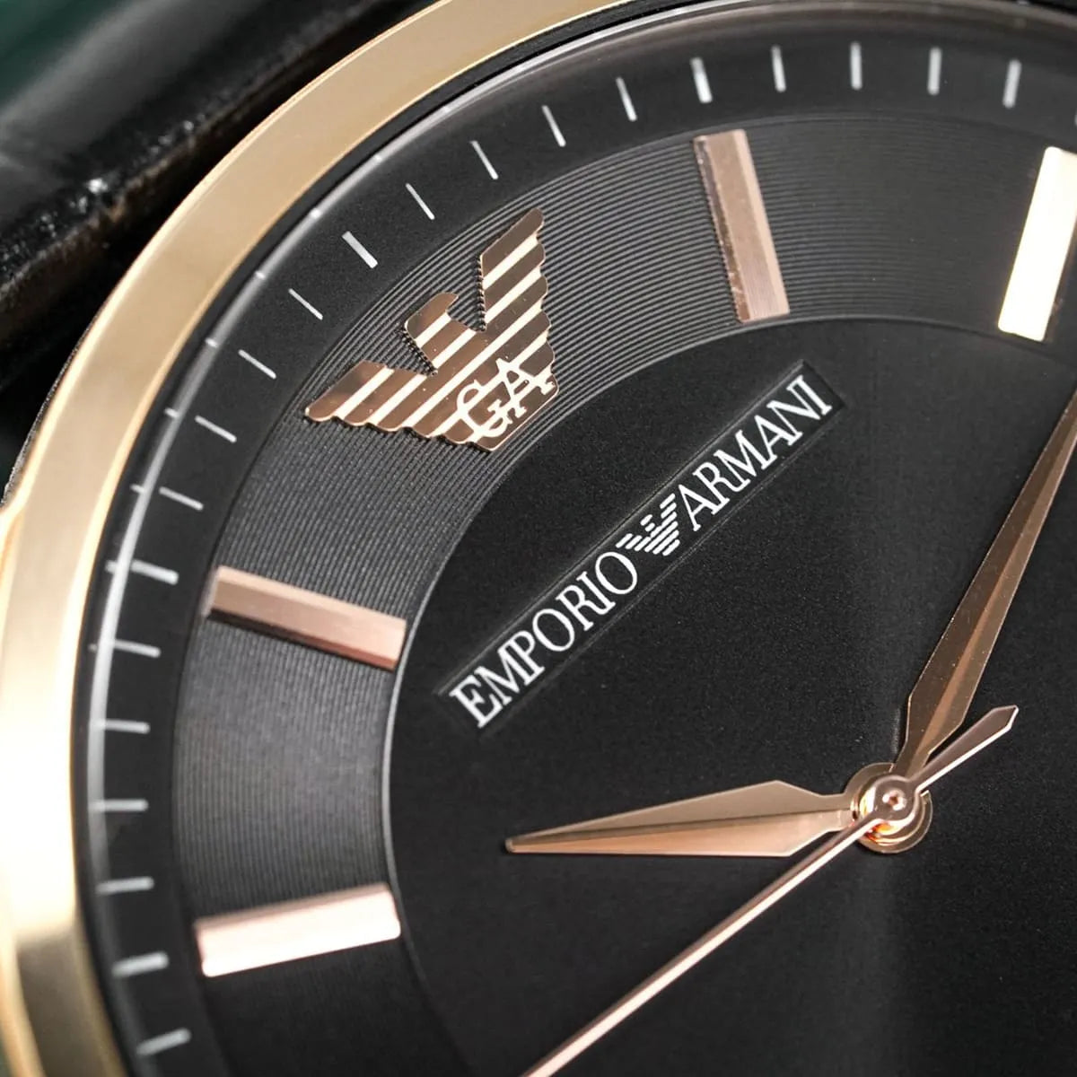 Emporio Armani Renato close-up of black dial showing eagle logo and rose gold hour markers