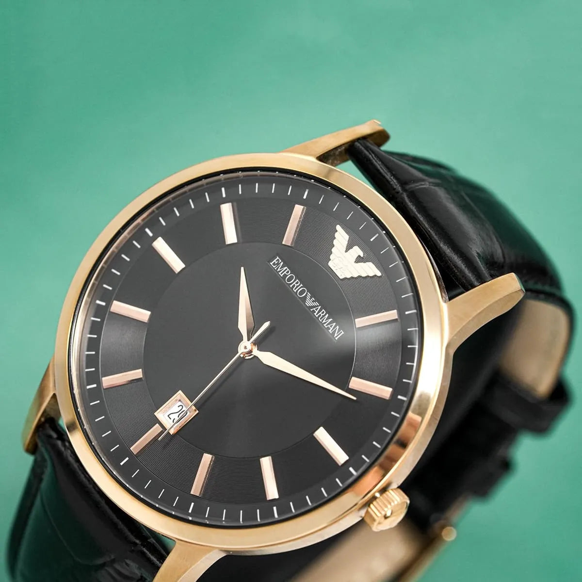 Emporio Armani Renato watch on wrist showing black dial with rose gold case and black leather strap