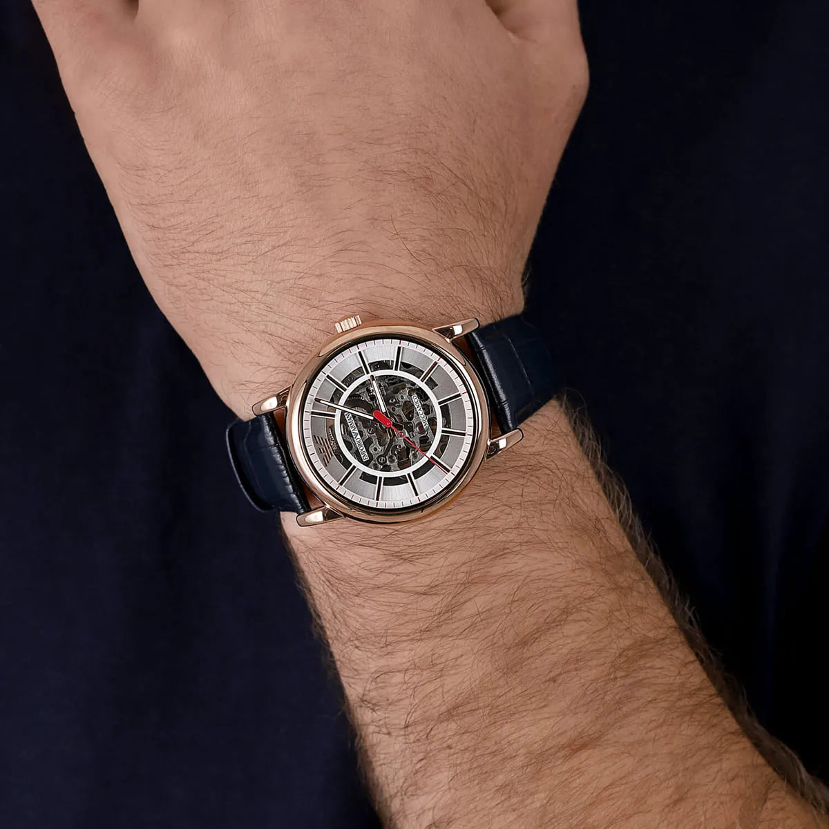 Emporio Armani AR60009 skeleton automatic watch on wrist with white dial and navy leather strap