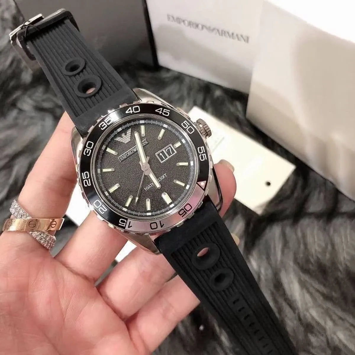 AR6044 Emporio Armani watch on wrist showing black dial, bezel markers, and box packaging