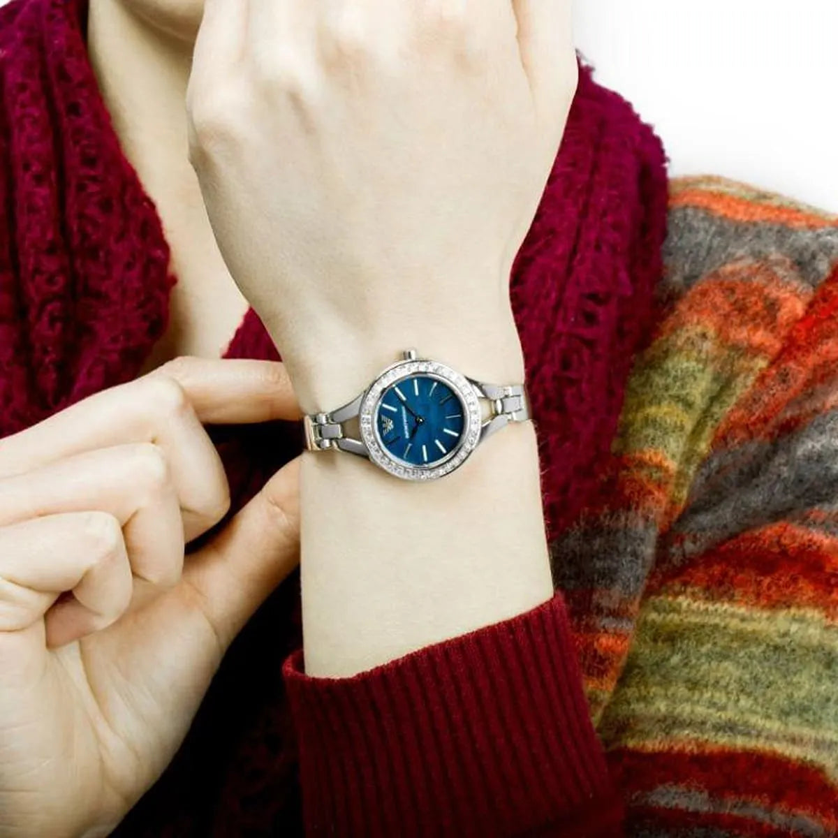 Watch worn on wrist showing blue dial and stainless steel bracelet