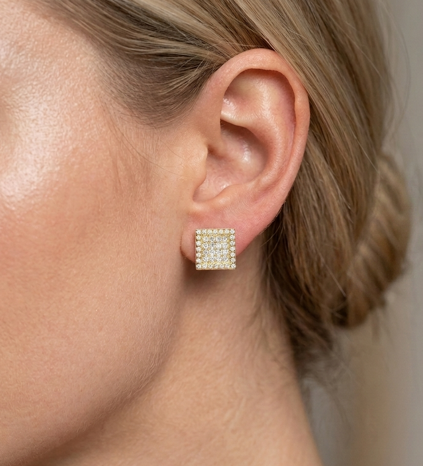 Gold iced out square earring worn on ear, showcasing cubic zirconia pave design