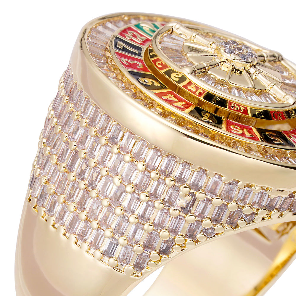 Iced out gold ring with colorful roulette wheel design and baguette diamond band, angled view