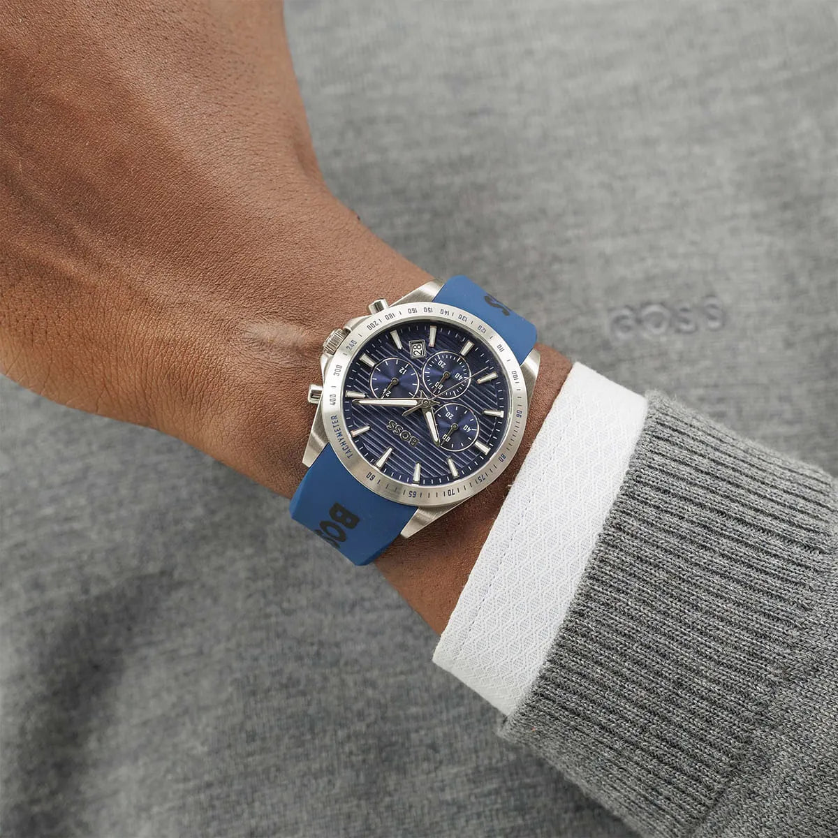 BOSS chronograph watch on wrist with blue silicone strap and dark blue dial