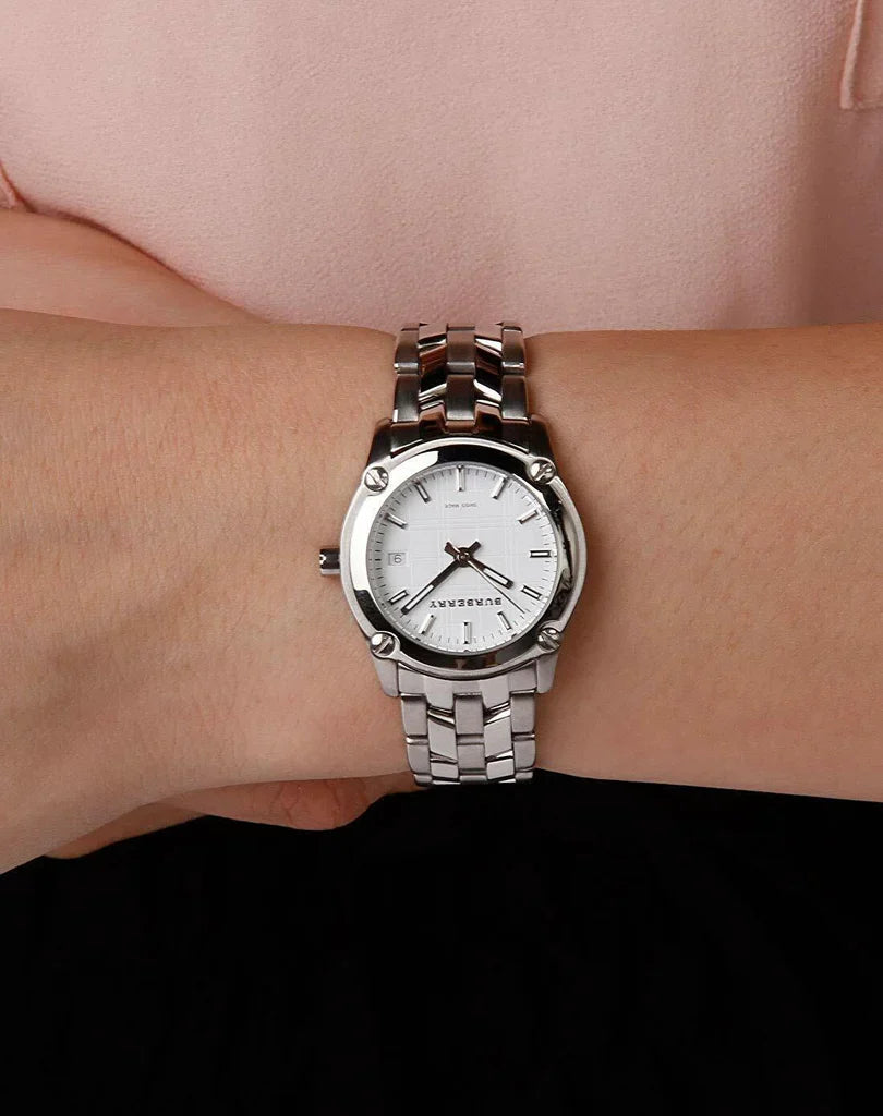 Burberry BU1853 Heritage Check watch on woman's wrist showing white dial and steel strap