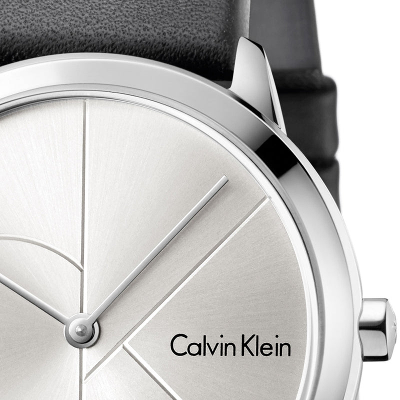Close-up of grey dial with geometric divisions and silver hands