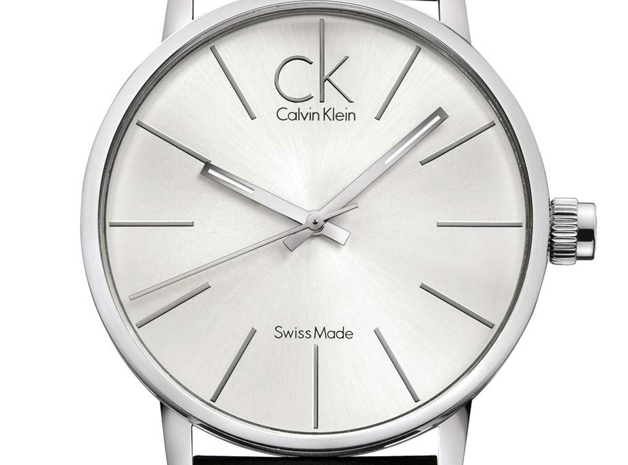 Close-up of silver dial with hour markers and Swiss-made movement text