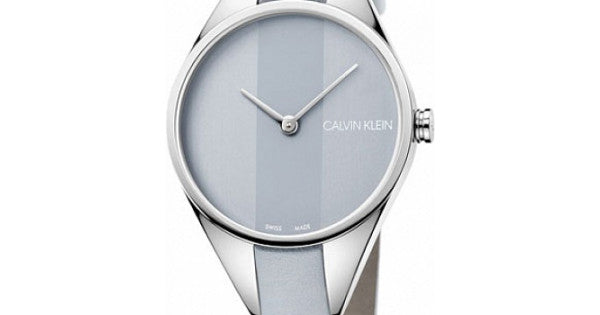 Angled view of Calvin Klein Rebel watch showing silver case and light grey leather strap