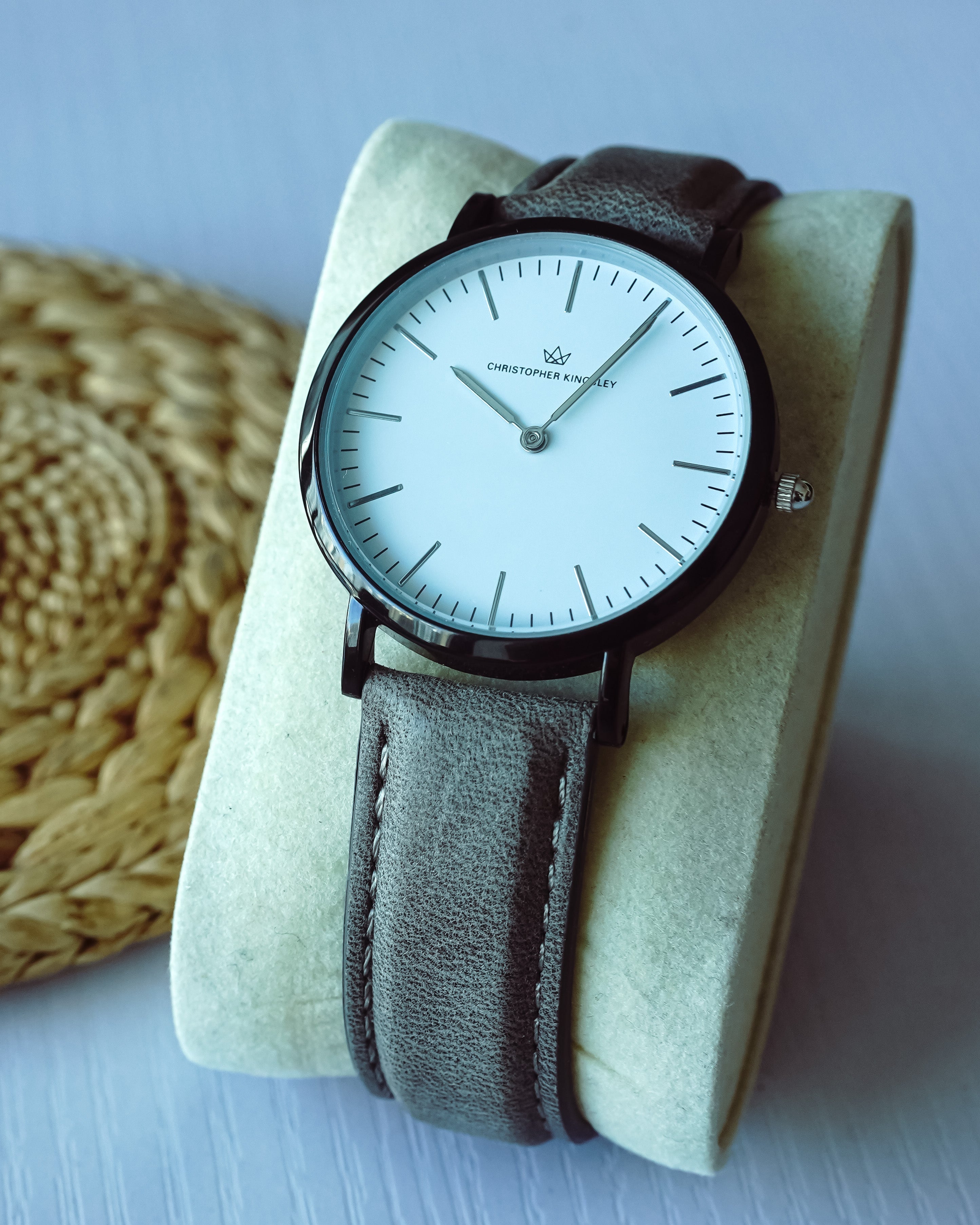 Christopher Kingsley watch on wrist with grey leather band, displayed on fabric holder
