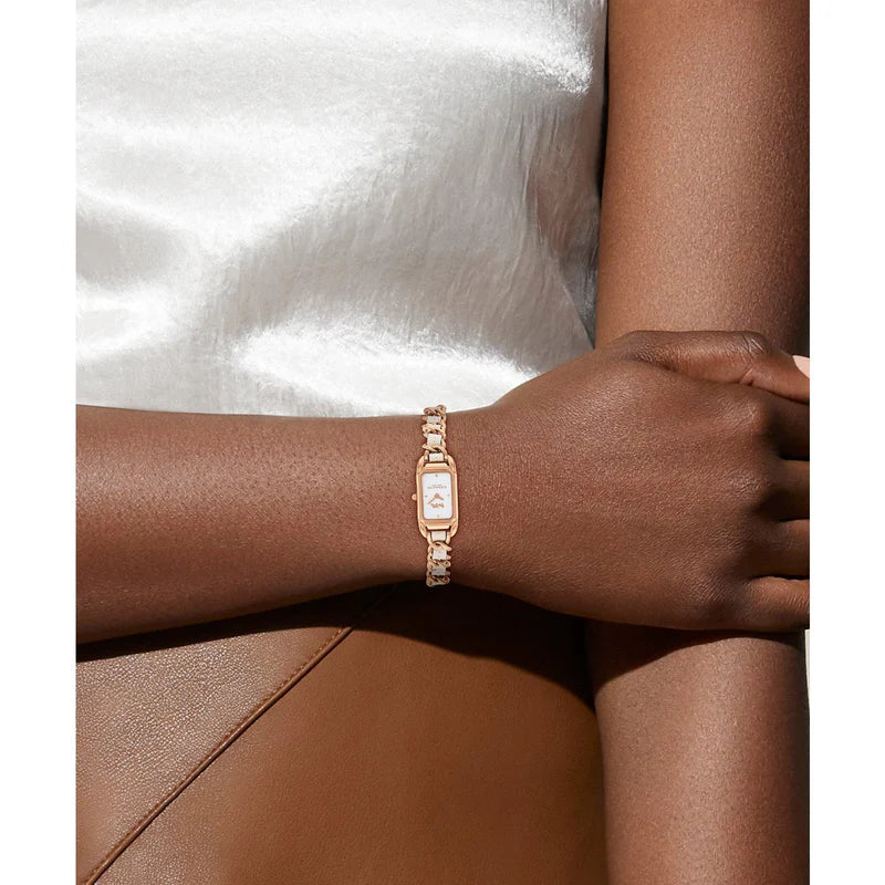 Coach rectangular rose gold watch worn on wrist with chain leather bracelet
