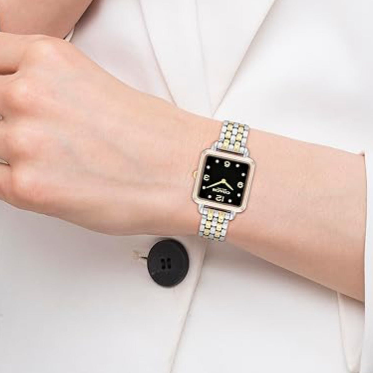 Coach women's watch worn on wrist with two-tone steel bracelet