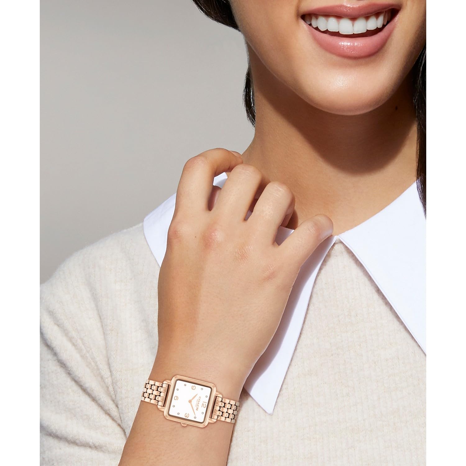 Coach Cass women's watch worn on wrist, rose gold case with white dial and crystal markers
