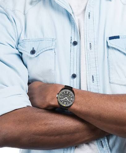 Coach Charter automatic watch worn on wrist with grey dial visible against light blue shirt