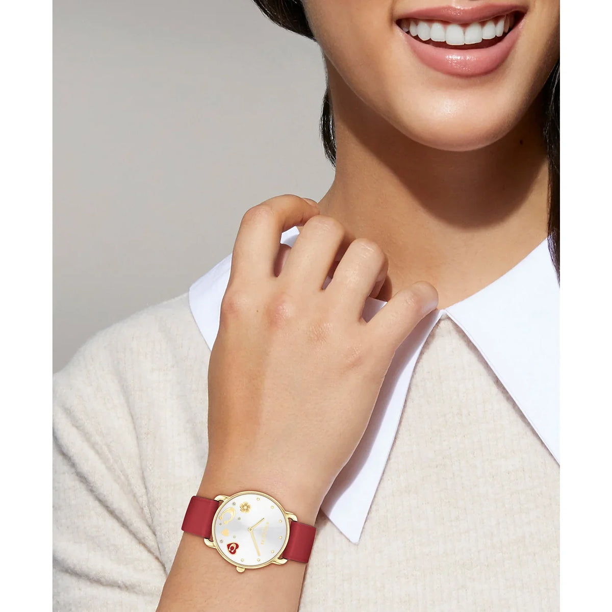Coach Elliot watch worn on wrist, silver dial with gold-tone case and red leather strap