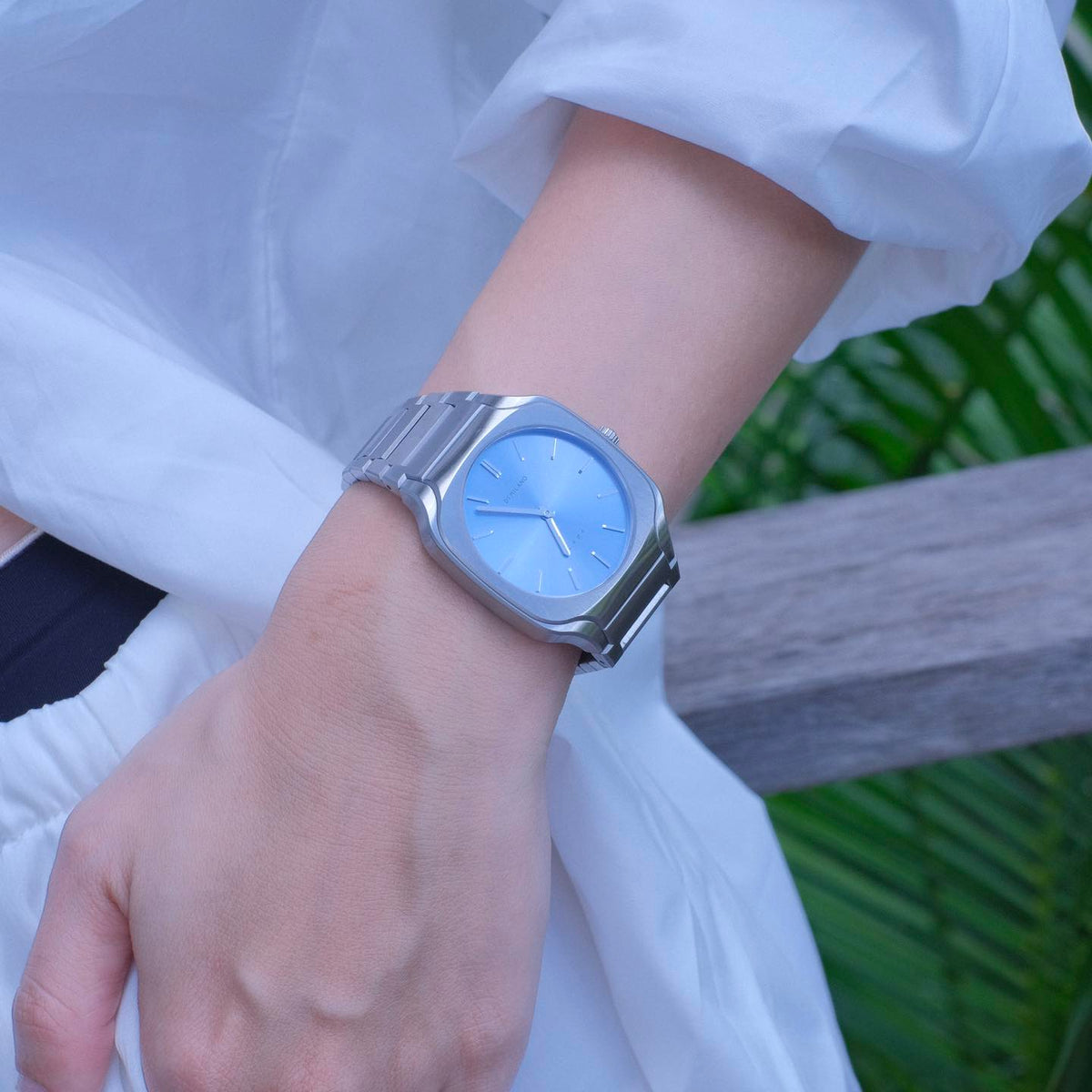 D1 Milano Square Maldives watch on wrist with silver strap and blue dial, outdoor setting