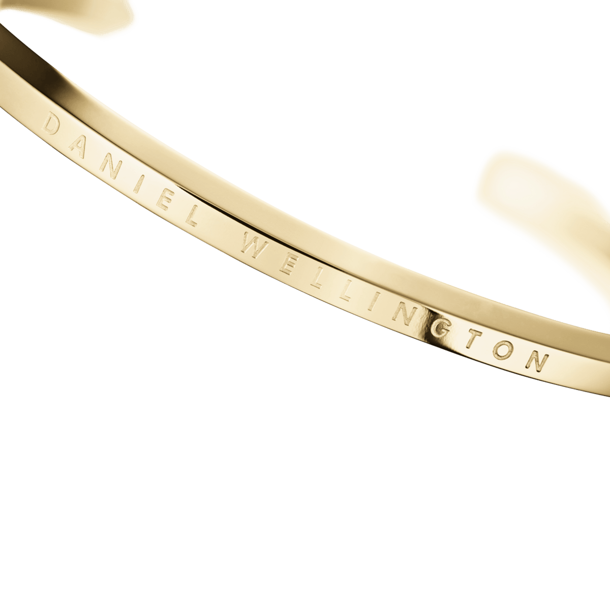 Close-up of engraved Daniel Wellington text on gold bracelet interior
