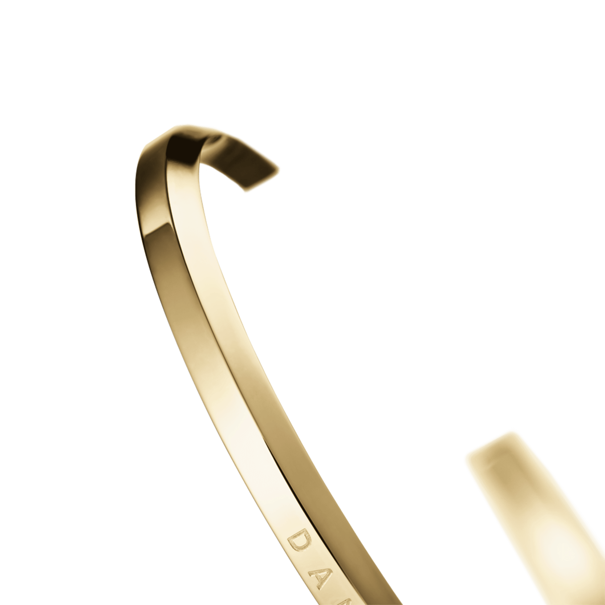 Side profile of gold cuff bracelet showing curved shape and engraving