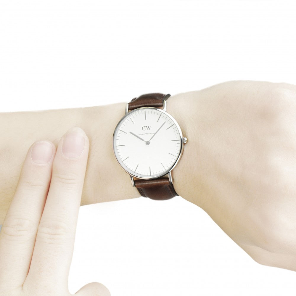 Wrist shot of Daniel Wellington Classic Bristol showing minimalist white face and dark brown strap