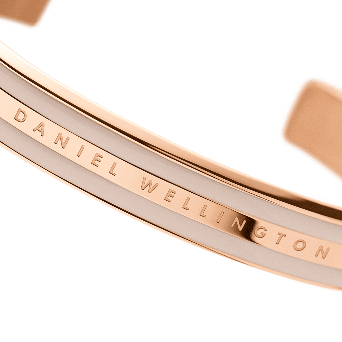Close-up detail of Daniel Wellington branding engraved on rose gold bracelet surface