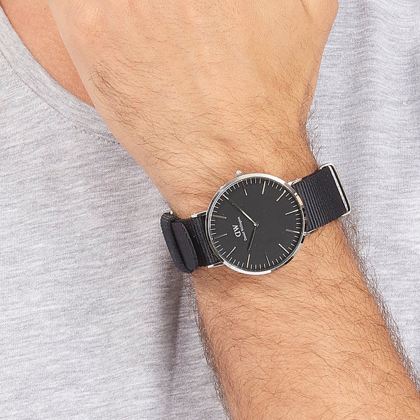 Daniel Wellington Cornwall 40mm watch worn on wrist with black dial and navy strap