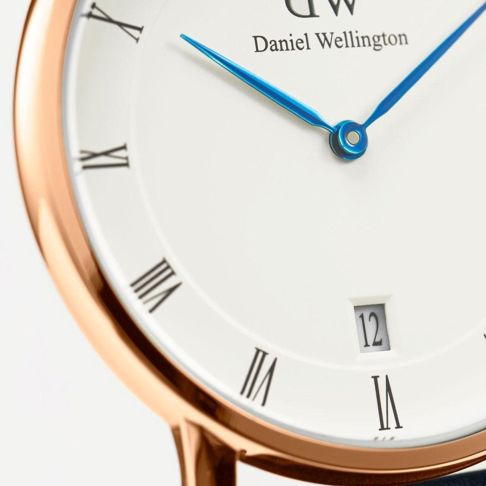 Close-up of white dial showing Roman numerals, blue hands, and date window