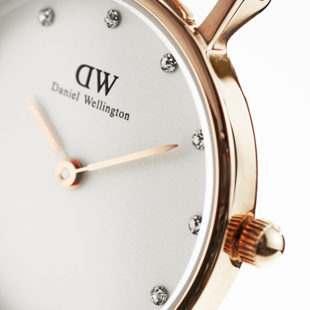 Close-up of Daniel Wellington Classy York dial with white face, rose gold hands, and silver applied indices