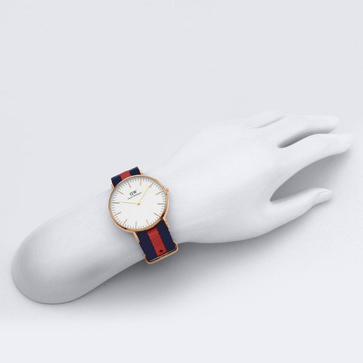 DW Oxford 36mm gold watch worn on wrist with navy red striped NATO strap