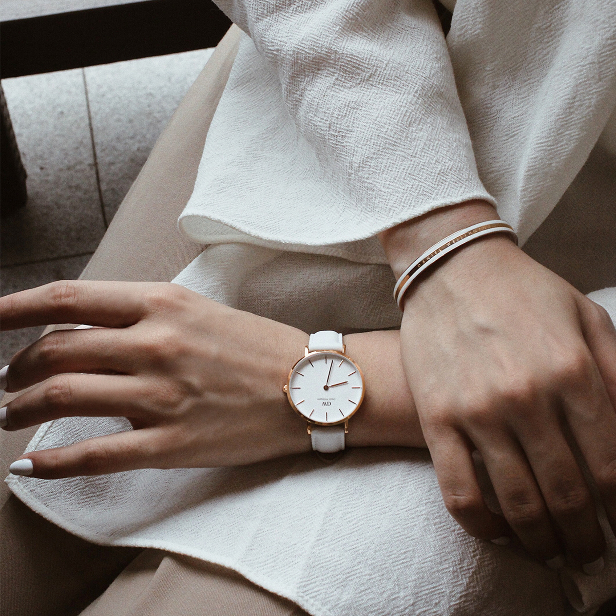 Daniel Wellington Petite Bondi watch worn on wrist with white leather strap and rose gold accents