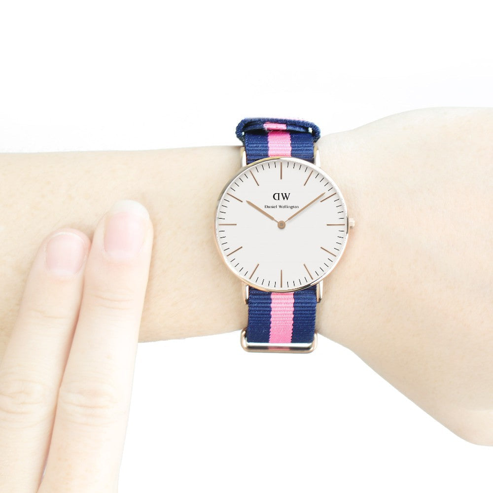 Close-up of Winchester watch on wrist featuring white dial and navy pink striped strap